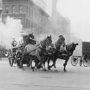 A Team of Horses pulls a steam pumper across paved streets toward a fire scene. - Art Print