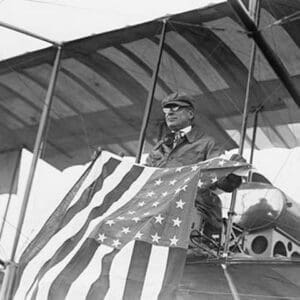 Aviator C.B. Harmon Unfurls Stars and Stripes from his pilot seat on his Biplane. - Art Print