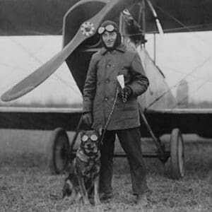 Aviator and His dog wear goggles in front of his Biplane - Art Print