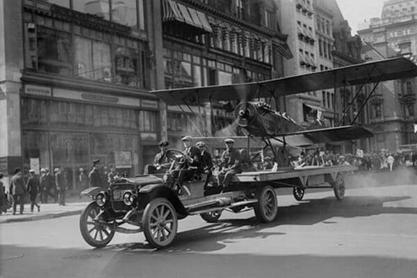Biplane with spinning propeller is towed down Fifth Avenue New York for July 4th Parade - Art Print