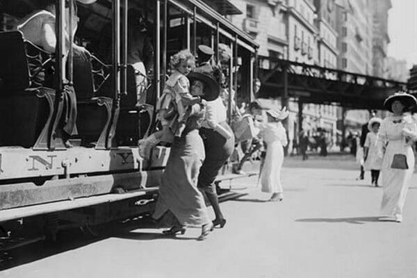 Woman lifts child off of an open sided Trolley Car on New York's Broadway - Art Print