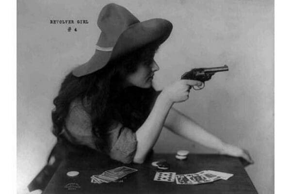 Young Cowgirl Hold Pistol Over a table of Playing Cards - Art Print